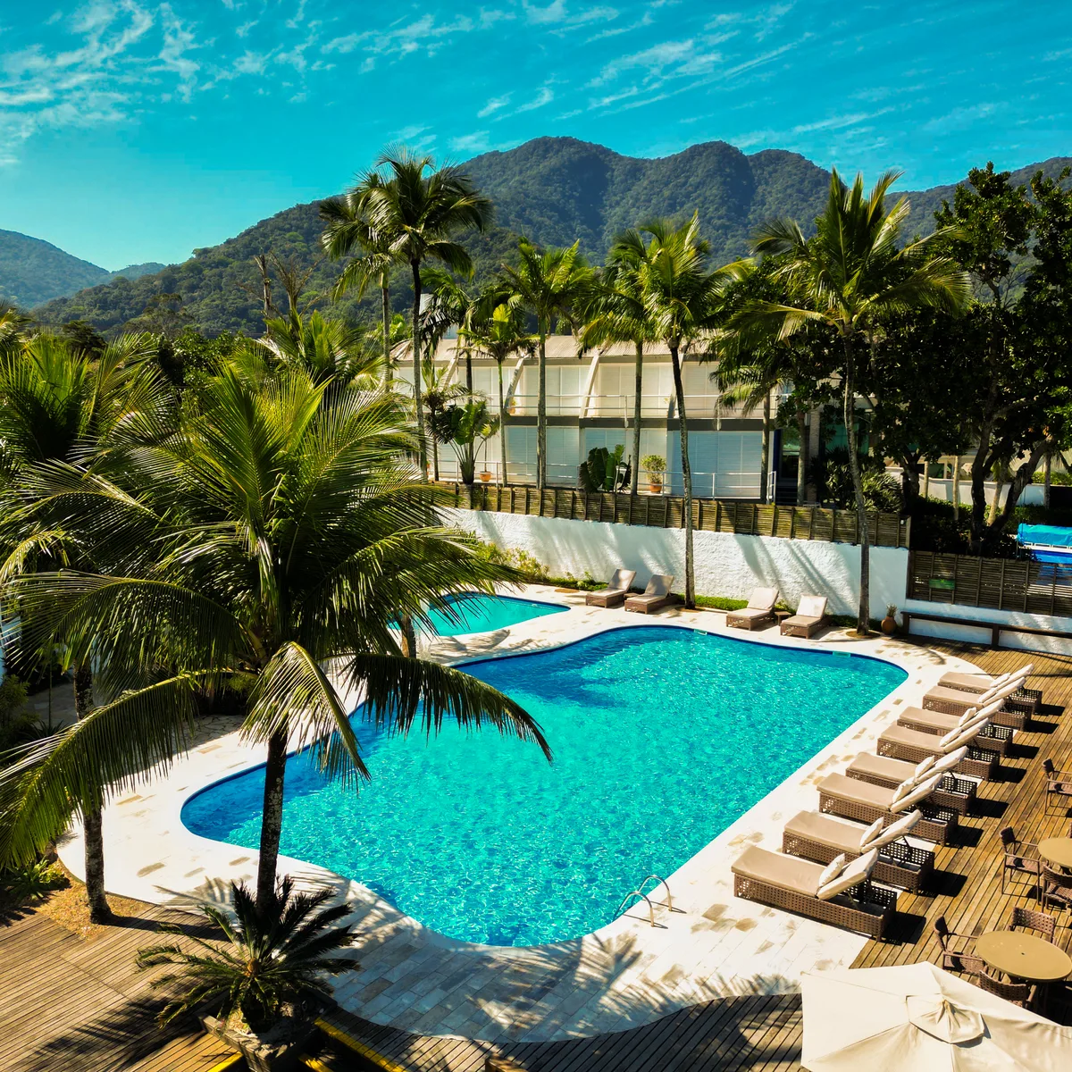 Piscina entre os coqueiros e a serra de Maresias