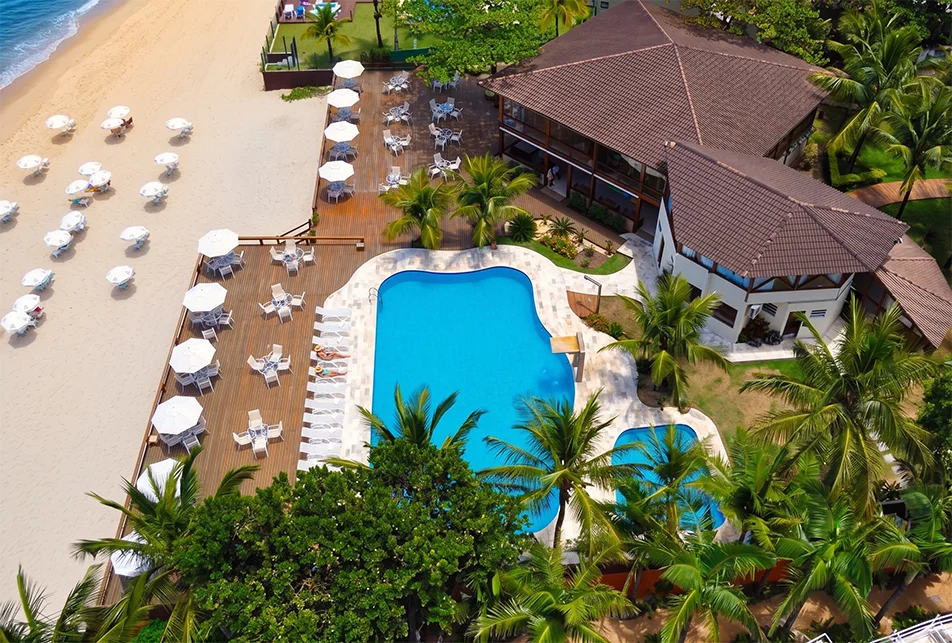 Vista aérea das piscinas, deck e praia do hotel